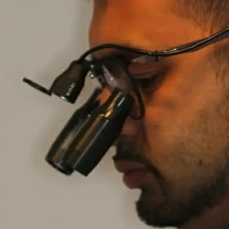 Dentist performing root canal treatment with loupes